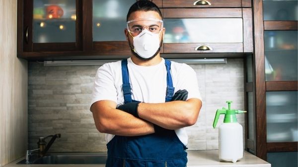 pest control technician in kitchen